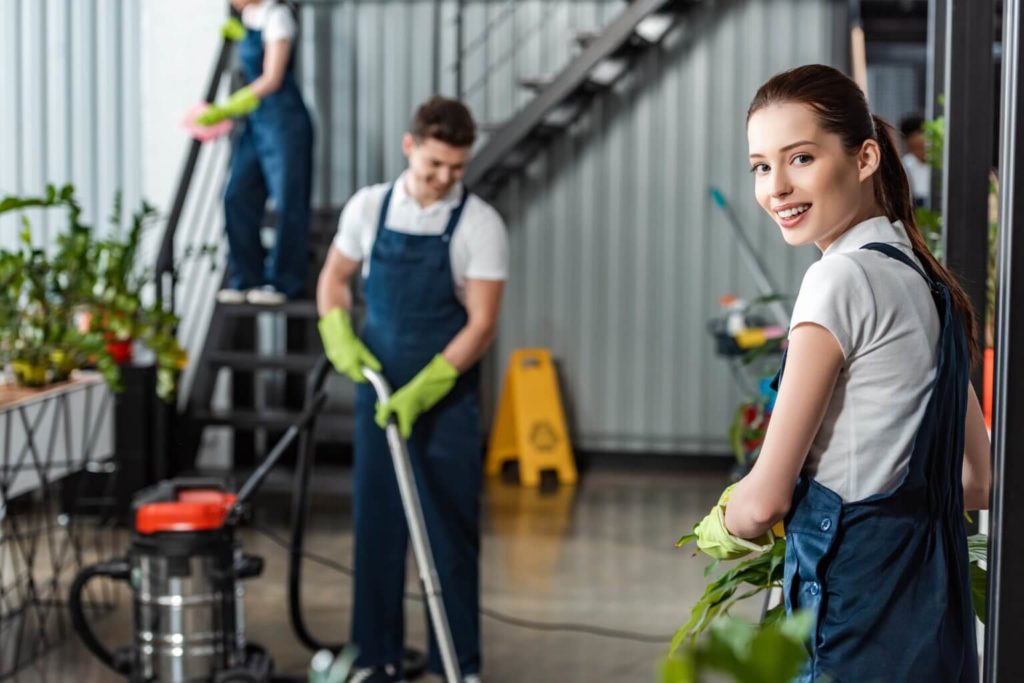 attractive-cleaner-smiling-at-camera-